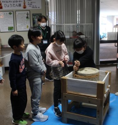 小学生が治水の歴史学び、石臼ひきやダイヤル式電話を体験